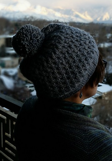 Free knitting pattern for Diamond Weave Hat with pompom - Nancy Wilson's design features diamond patterns on a background of purl stitches. Uses only one skein of the recommended yarn, even including pompom.