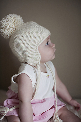 Free knitting pattern for Baby Earflap Hat knit seamlessly with braided ties and optional pompom